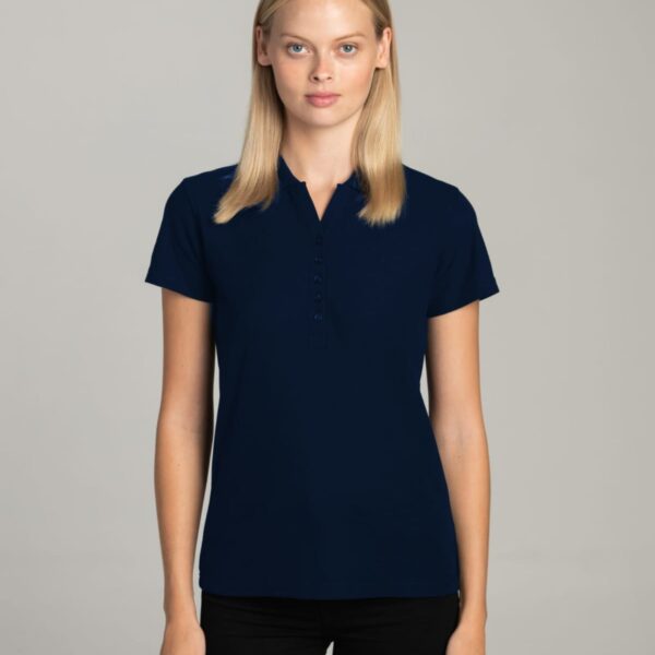 Woman in a navy blue short-sleeve polo shirt standing against a plain gray background.