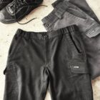 Black hiking boots and two pairs of gray shorts on a textured surface.