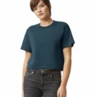 Woman in a plain dark blue cropped t-shirt and black jeans, standing against a white background.