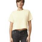 Person in a light yellow crop top and black jeans standing against a plain white background.