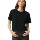 Woman with long red hair wearing a black t-shirt and dark jeans, standing with hands in pockets.