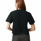 Woman with long red hair wearing a black t-shirt and gray jeans, seen from the back.