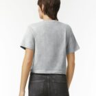 Person with short hair wearing a gray t-shirt and black jeans, facing away from camera.
