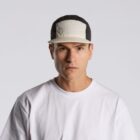 Man in a white t-shirt and two-tone cap facing forward against a plain background.