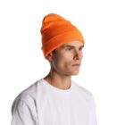Person wearing an orange beanie and white t-shirt, looking to the side against a white background.