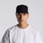 Man in a white t-shirt and black cap looking straight at the camera against a plain background.