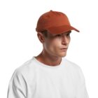 Man in a white shirt wearing a rust-colored baseball cap, looking to the side.