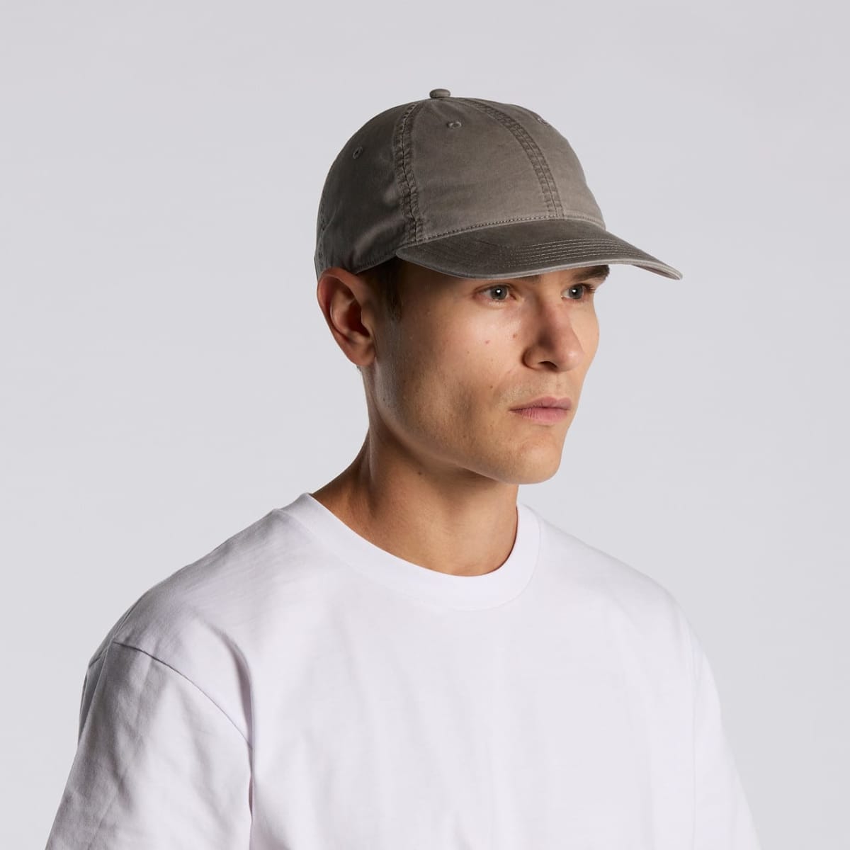 Person in a white shirt and gray baseball cap looking slightly to the side.