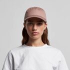 Woman in a beige cap and white t-shirt facing forward against a plain background.