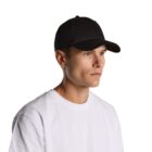 Person in a black baseball cap and white shirt looking to the side against a white background.