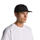 Man in a white t-shirt and black baseball cap looking to the side against a white background.