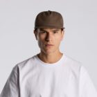 Man wearing a brown baseball cap and white t-shirt, facing forward against a plain background.