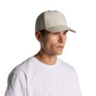 Person in a white t-shirt and beige baseball cap looking to the side against a white background.