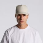 Man wearing a plain white T-shirt and beige cap, looking straight at the camera.