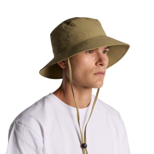 Person in a white shirt wearing a tan bucket hat with chin straps, facing left.