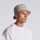 A person wearing a beige bucket hat and a plain white t-shirt, facing left.