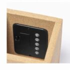 Close-up of a black control panel with buttons inside a wooden box or compartment.