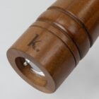 Wooden cylinder with a lens on one end and a small K. engraved on the side.