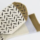 Cream socks with brown toes and black arrow patterns on the sole, laid on a white background.
