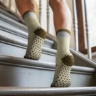 Person wearing non-slip socks walking up wooden stairs.
