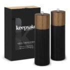 Black salt and pepper grinders with wood tops, next to a black keepsake collection box.