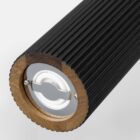 Close-up of a black, ridged cylindrical object with a metal and plastic end cap.