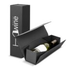 A wine bottle in an open black gift box next to its closed lid.