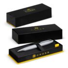 Silver pen in an open black and yellow Cross gift box, with closed boxes in the background.