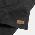 Black fabric with a small brown leather patch labeled keepsake sewn onto the corner.