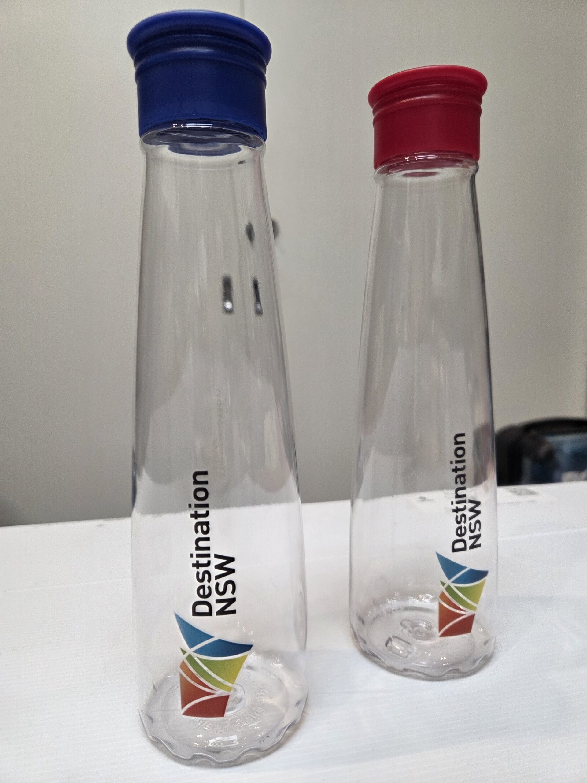 Clear bottles with the Destination NSW branded onto it.