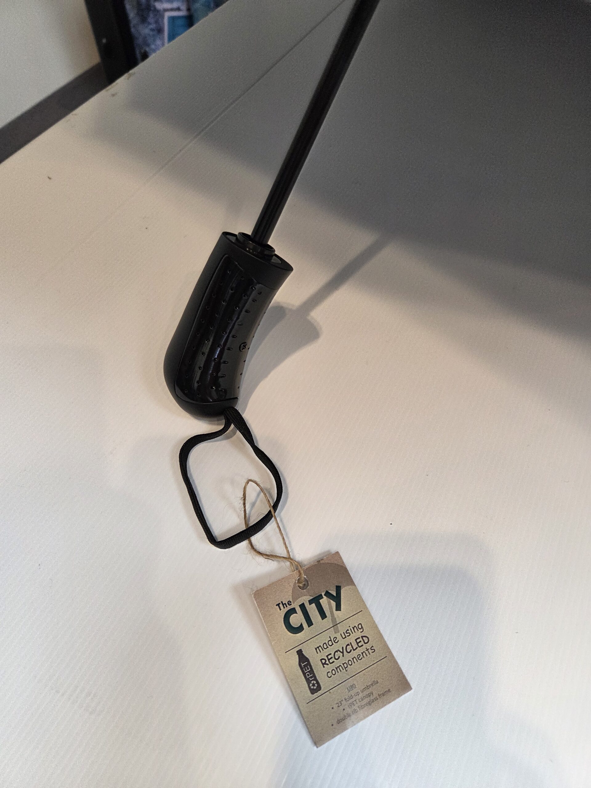 black umbrella handle with a paper tag