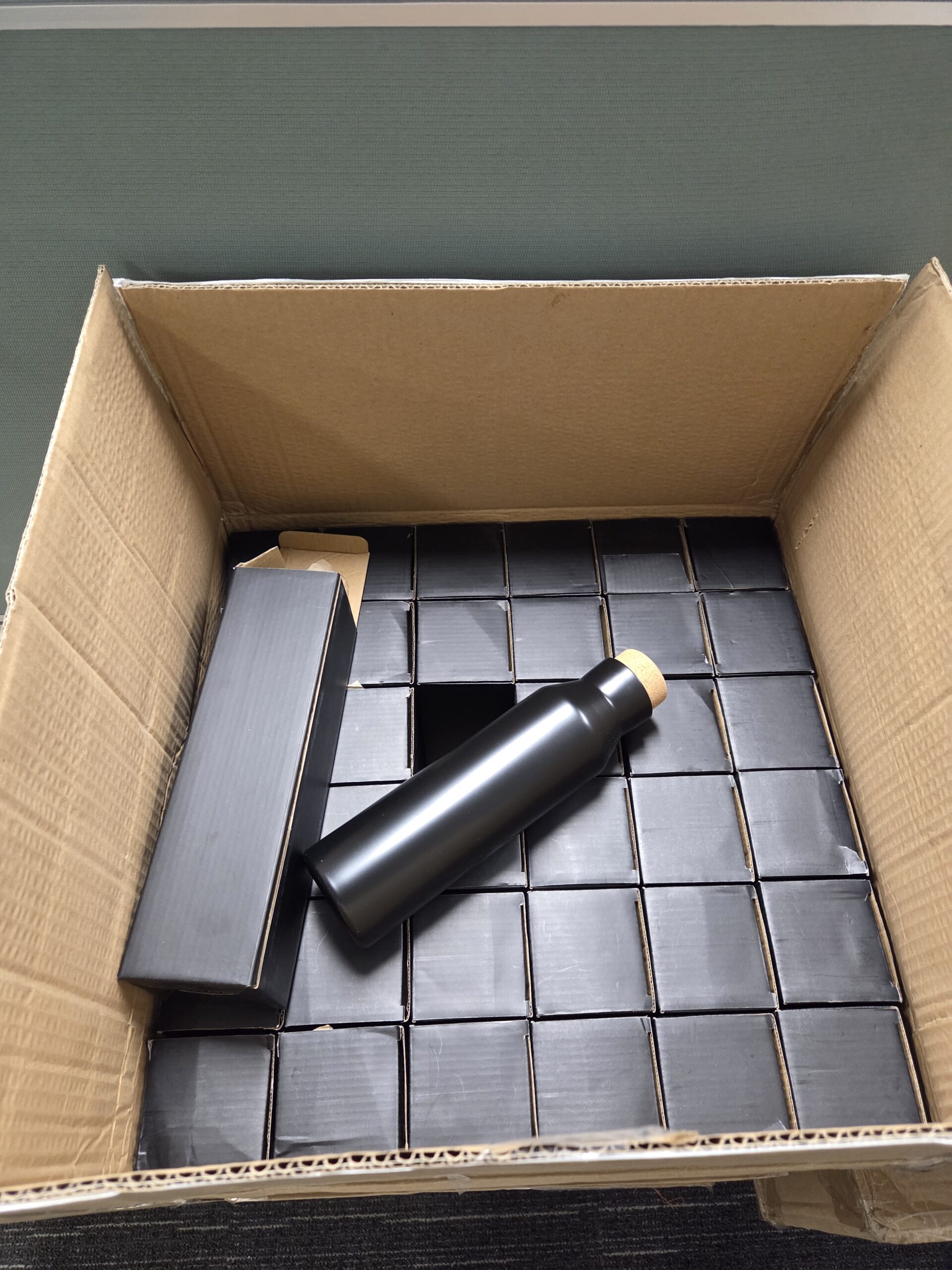 a delivery box full of black metal bottle boxes