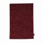 A rectangular, textured maroon cloth with a small black tag on the right edge.