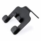 Black plastic car headrest hook with two prongs for holding bags or items.