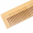 Close-up of a wooden comb with evenly spaced teeth on a white background.