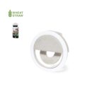 Round white clip-on selfie light made from wheat straw, shown attached to a phone.