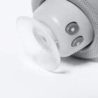 Close-up of a baby pacifier attached to a gray object with two buttons.
