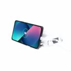 Smartphone wirelessly charging on a stand, cable and plug visible in the background.