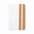 Closed notebook with a white cover and cork accent, secured by a white elastic band.