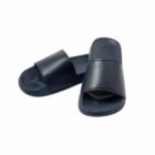 A pair of black slide sandals on a white background.