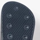 Black shoe sole with circular grips and a textured, crisscross pattern.