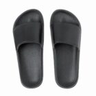 A pair of plain black open-toe slide sandals on a white background.