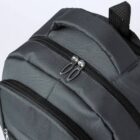 Close-up of a black backpack with zippers and a top handle visible.
