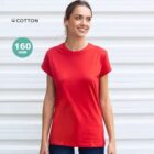 Woman in a red t-shirt standing and smiling in front of a white wall; 160 GSM cotton.