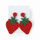 A pair of strawberry-shaped earrings with green tops and black dots on red fruit.