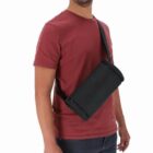 Man in a red shirt wearing a black sling bag across his chest.