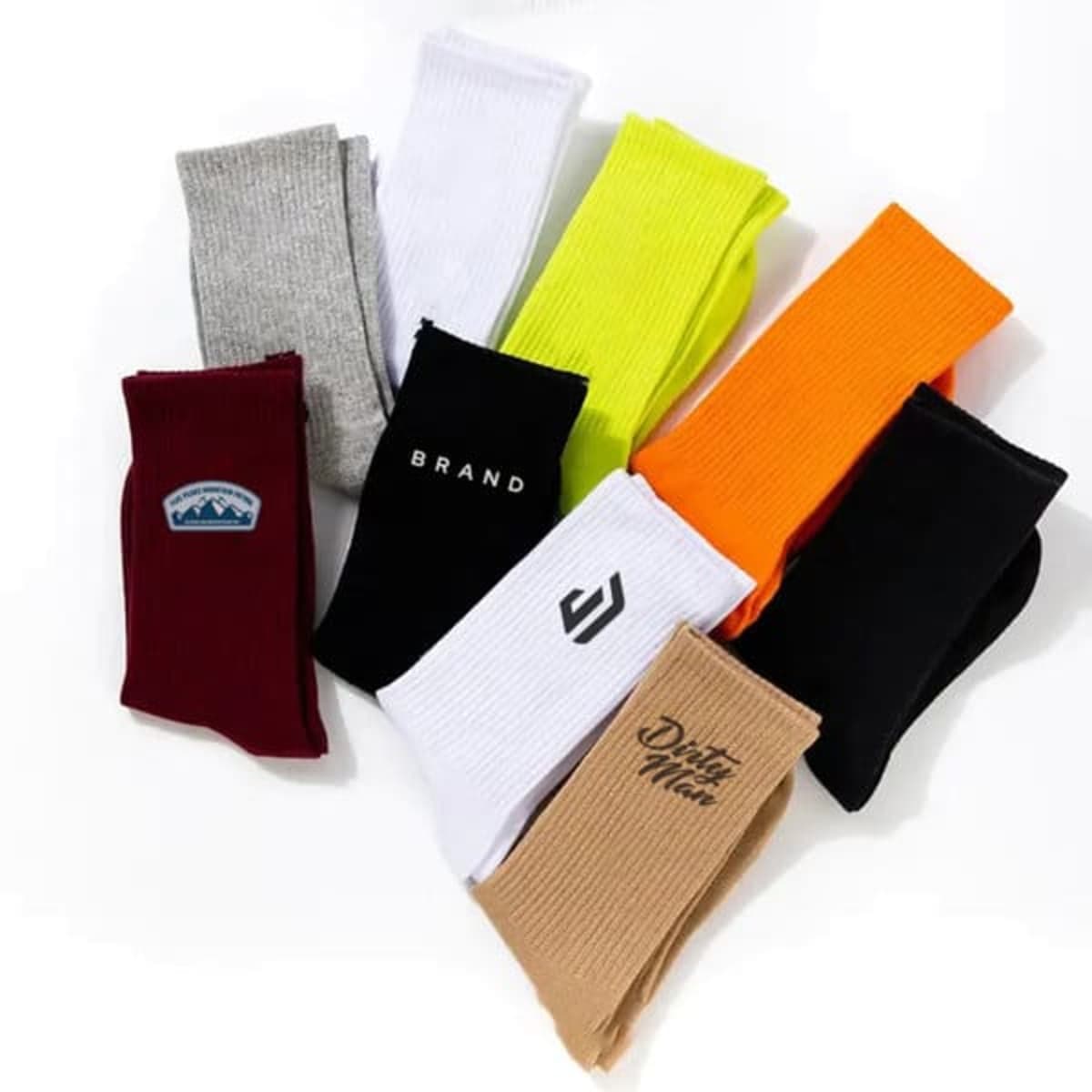 Nine pairs of colorful socks arranged in a fan, some with logos or text on them.