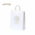 White recycled paper bag with gold emblem and handle, on a plain white background.