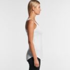 Woman in a white tank top and black pants standing in profile against a plain background.