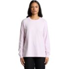 Woman wearing a light pink long-sleeve shirt and black pants, facing forward.